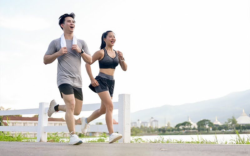 Active couple jogging together, representing healthy knee function and recovery.