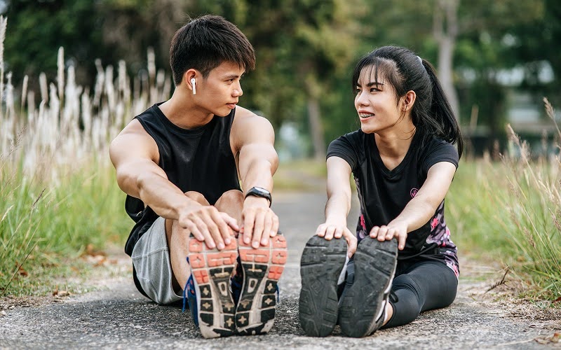 Athletes stretching outdoors to prevent meniscus tears and knee pain.