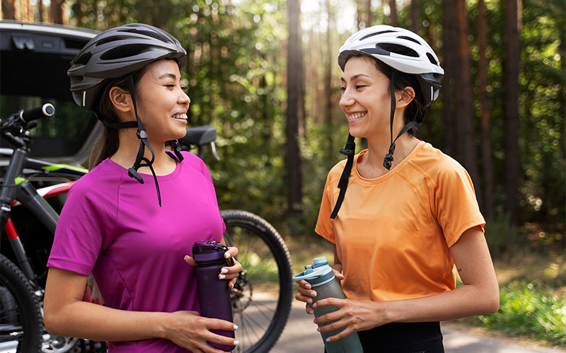 Two female cyclists smiling and talking after a ride