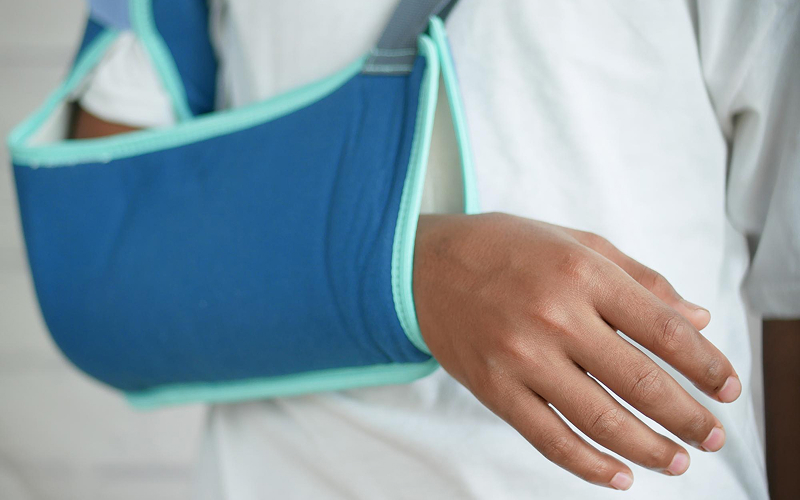 Patient wearing a medical arm sling for shoulder recovery.